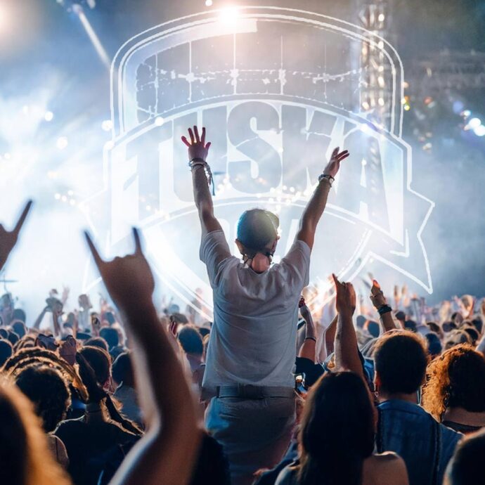 AI:lla luotu kuva yleisöstä isoilla festareilla. Kuvaan häivytetty Tuska-festivaalien logo.