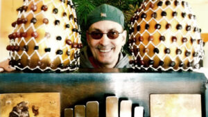 Kuva henkilöstä kurkistamasta kahden koristeellisen kookoksen välistä, hyllyn takaa.